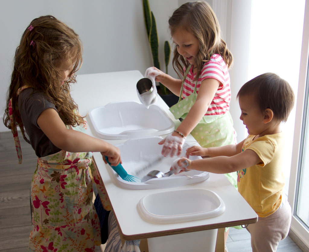 Children washing dishes at a washing station