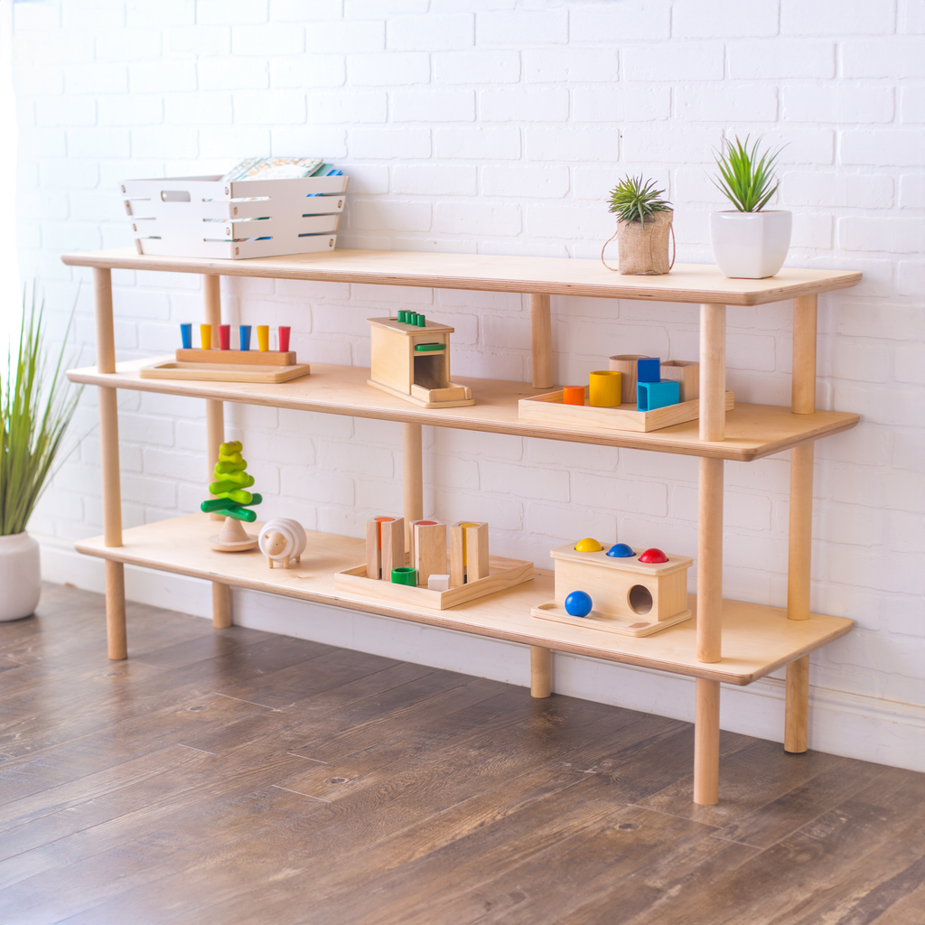 A large configuration of the Luce open shelving with wooden toys and small plants on top