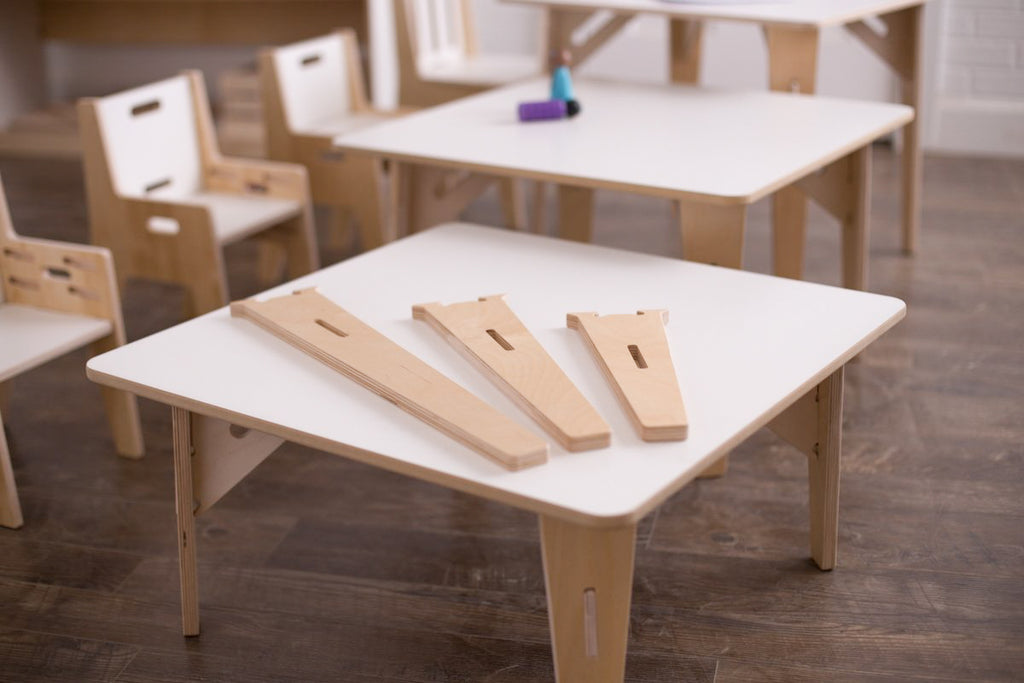 Additional classroom legs sitting on a white laminate birch rectangular table.