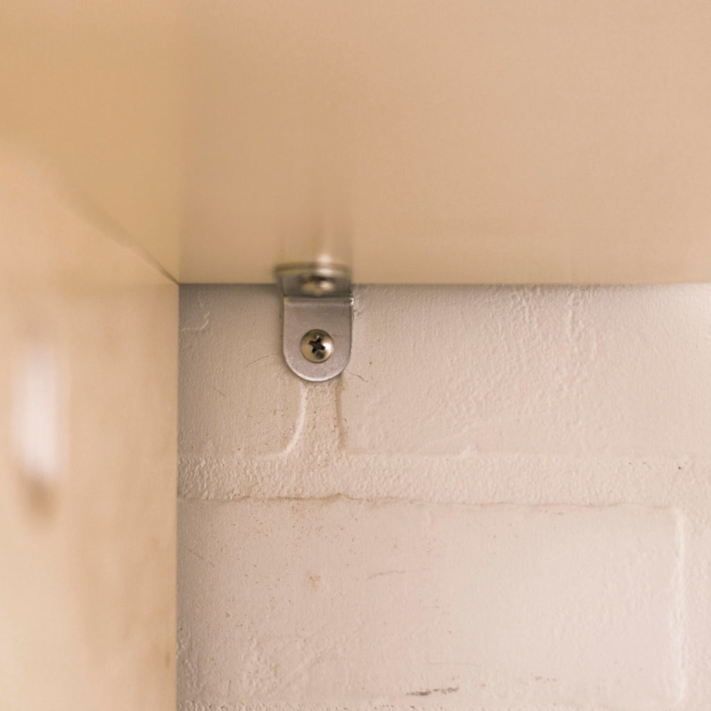 Close-up of a screw securing the childrens wardrobe to the wall