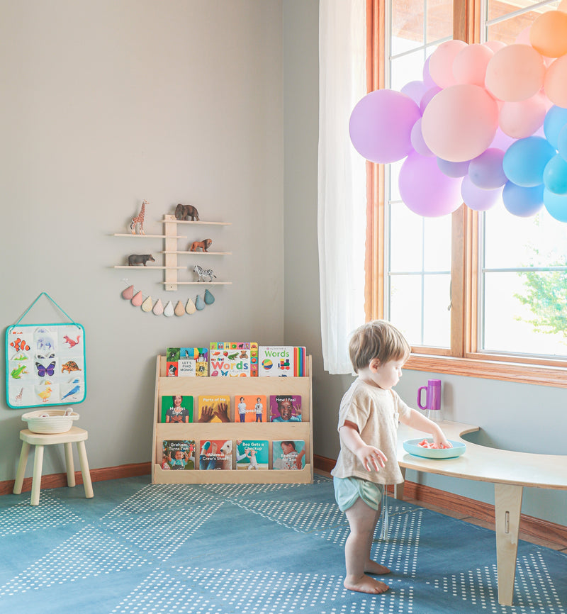 Child standing at a table in a colorful playroom