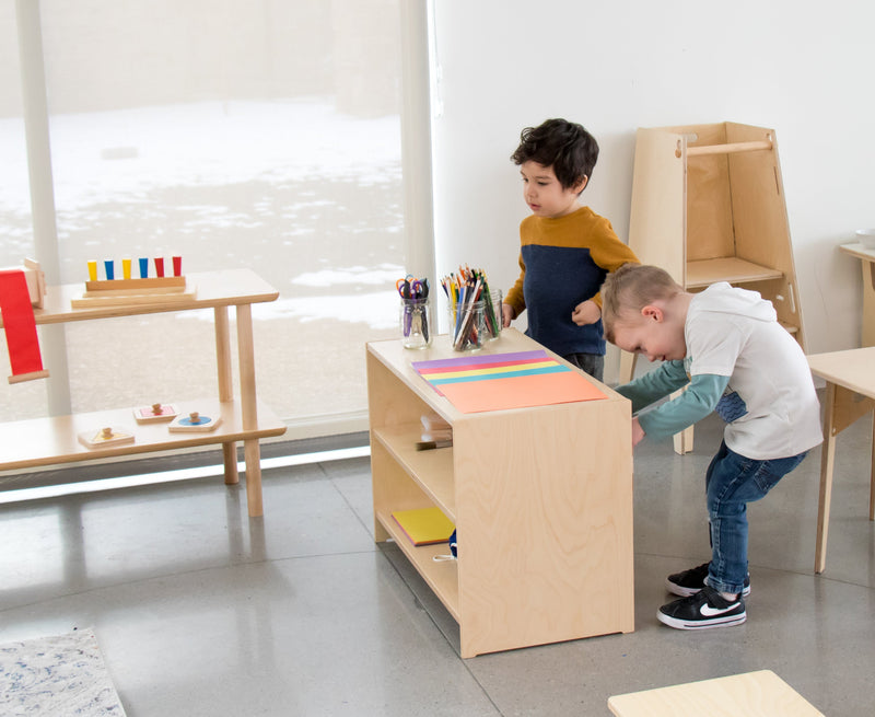 Children standing at a shelf in a Montessori classroom