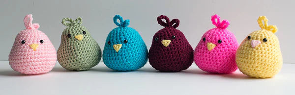Row of colored crochet birds