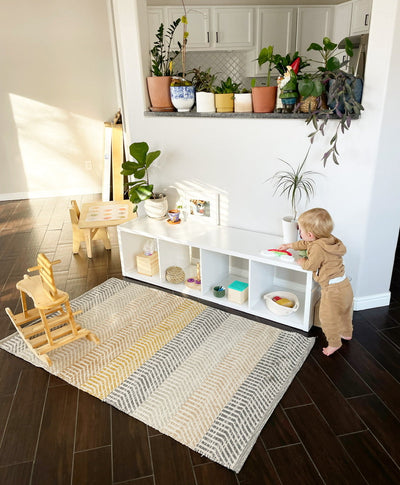 Child playing on a low shelf 