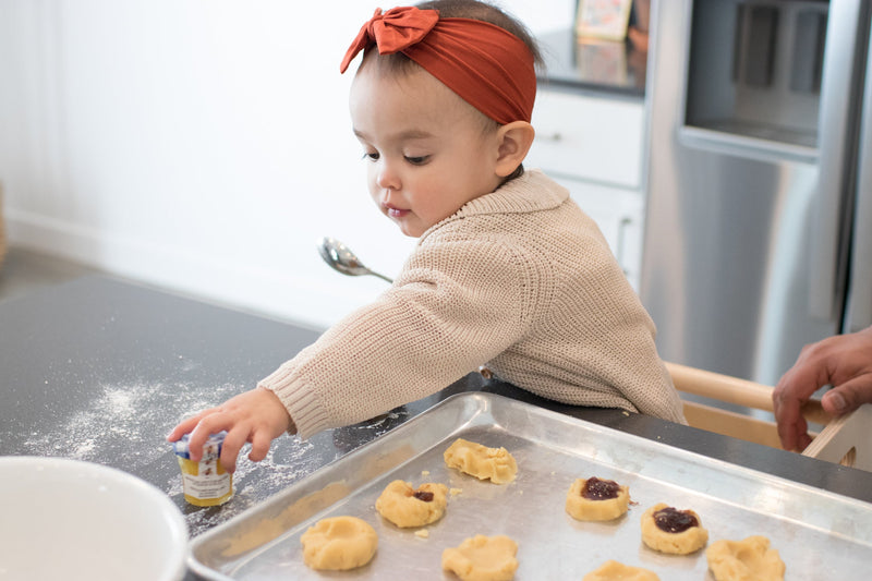 Toddler baking cookies in a Toddler Tower
