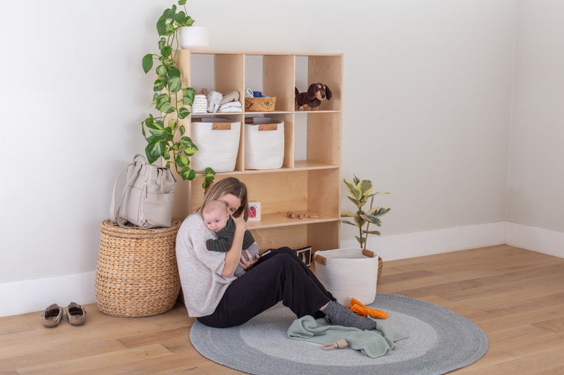 Mother with Infant Son in front of a Wooden Shelf
