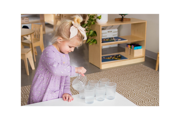 Girl pouring water into glass cups