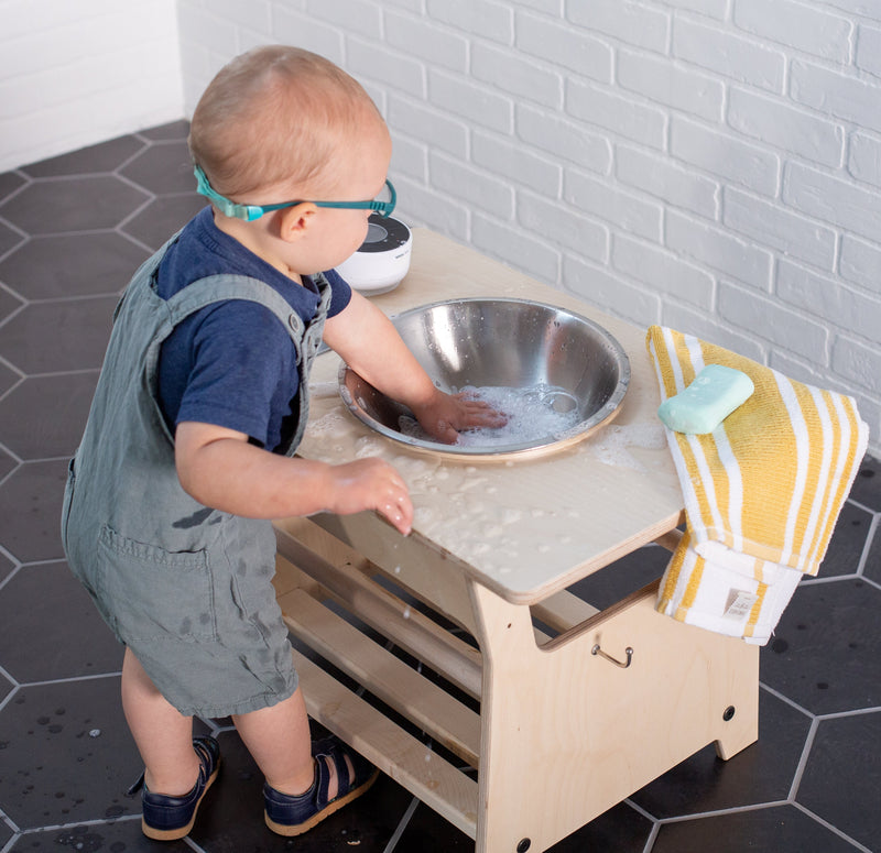 Child playing at a handwashing station