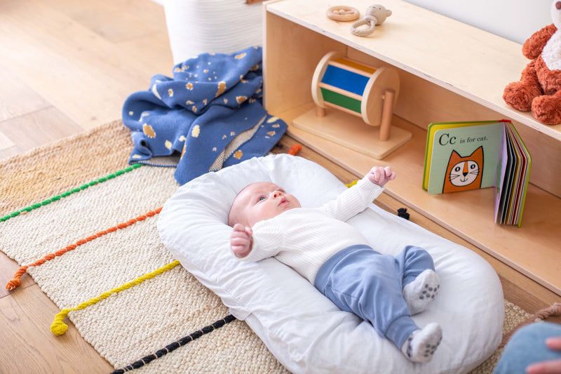 Newborn in front of an Infant Shelf