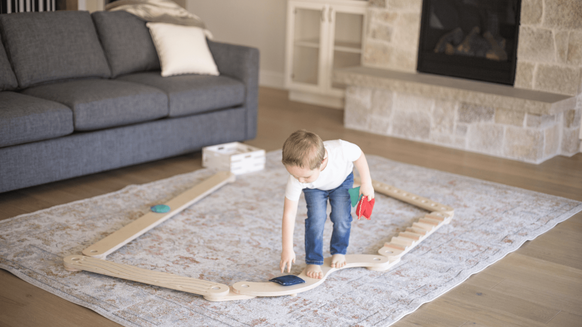 boy playing with a wooden balance beam 