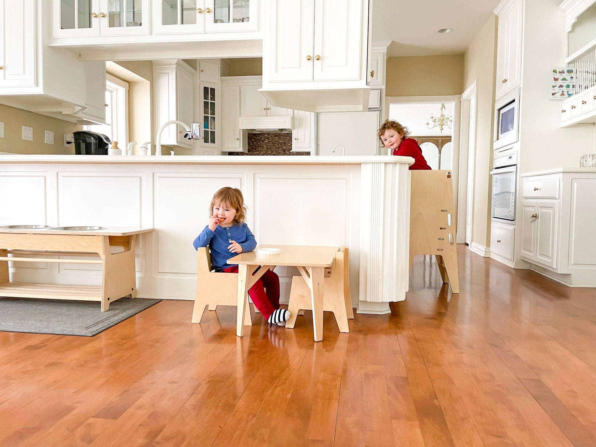 two toddlers using Montessori kitchen furniture