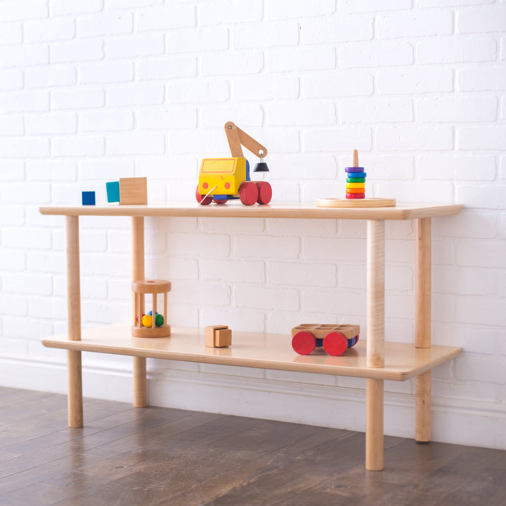 A double configuration of open wood shelving with wooden toys on it