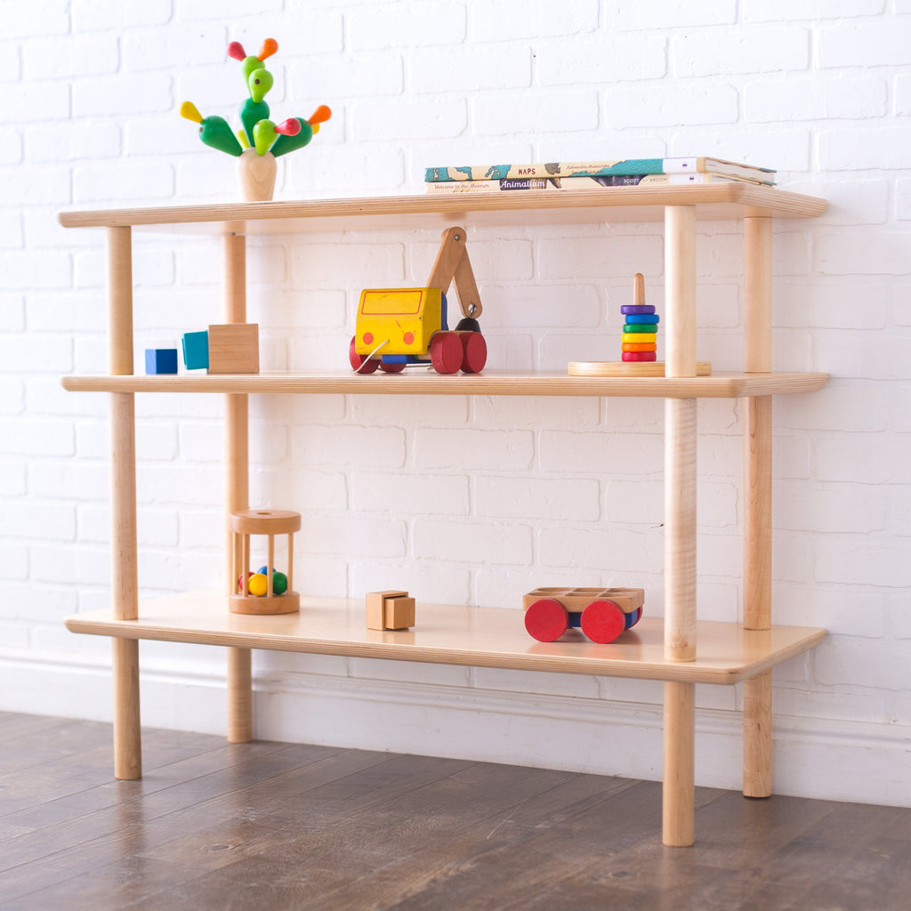 Open wood shelving showed with bright wooden toys on each shelf