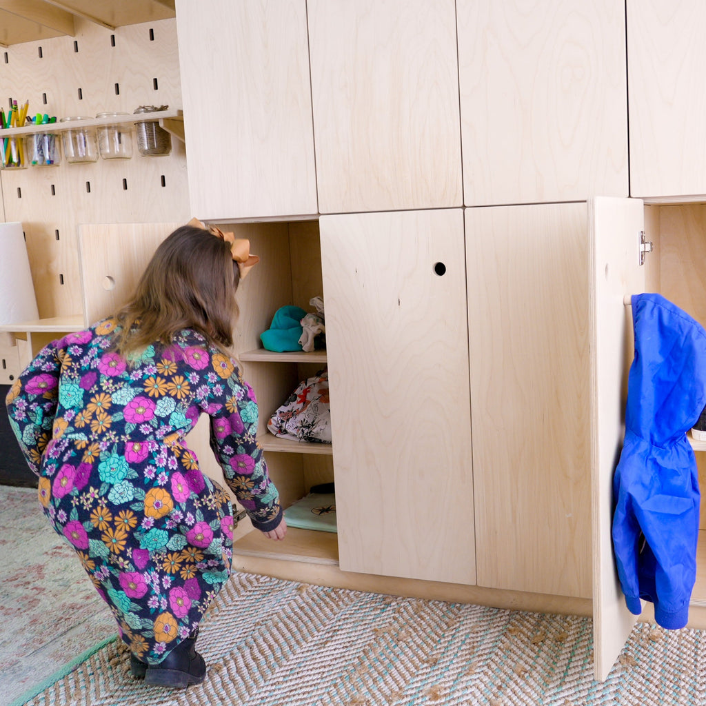 A small girl getting out materials from a 2x5 locker storage