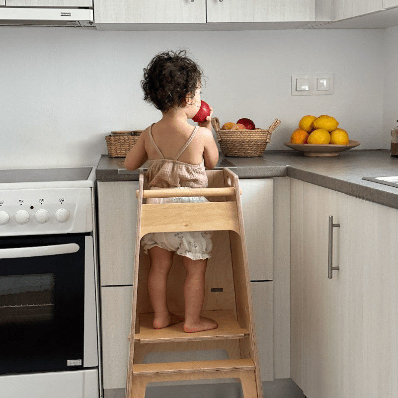 Child standing in a toddler tower.