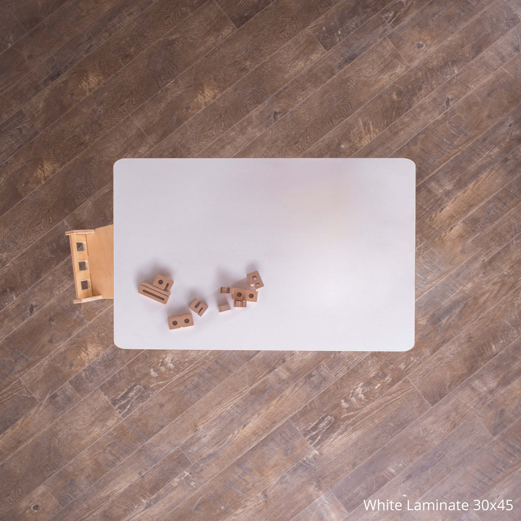 White laminate sheet on a wooden floor with small wooden blocks.