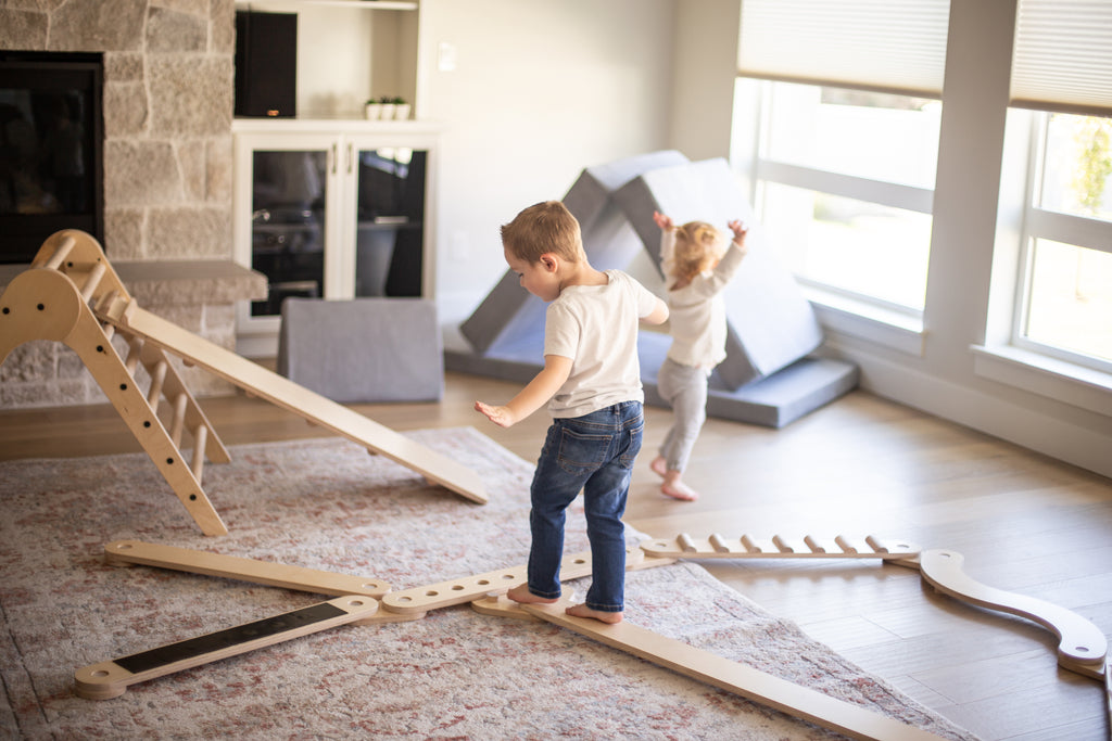 children playing with balance beam and climbing triangle