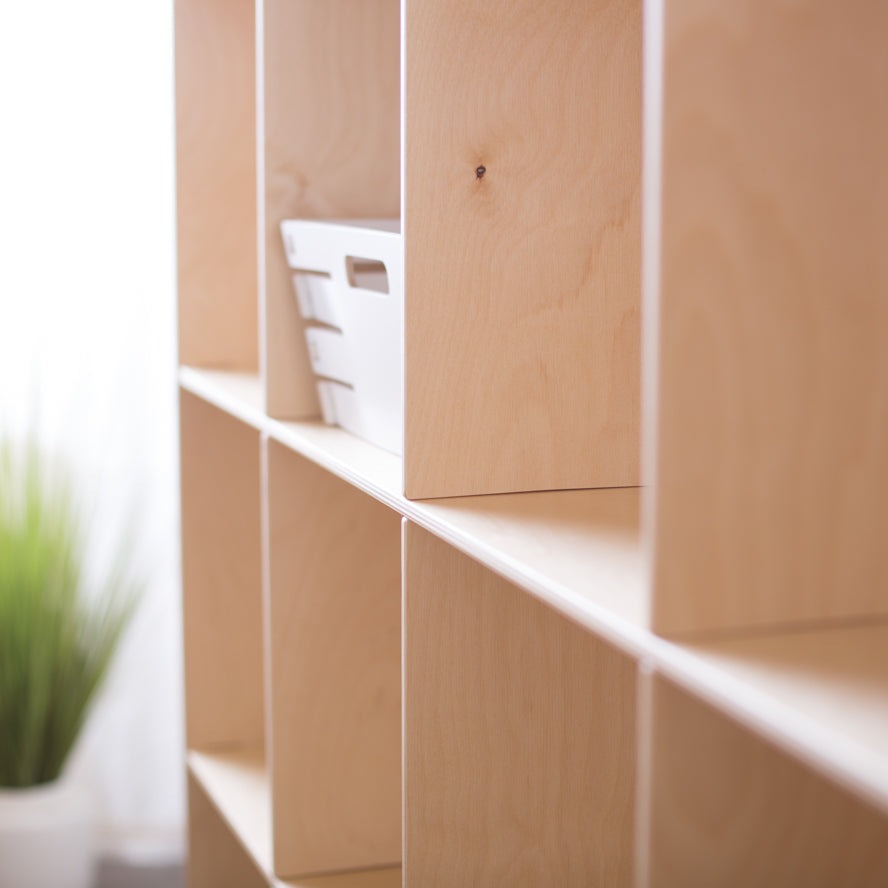 Close up of a wooden sixteen cube shelf, showing how the vertical dividers intersect with the shelves. 