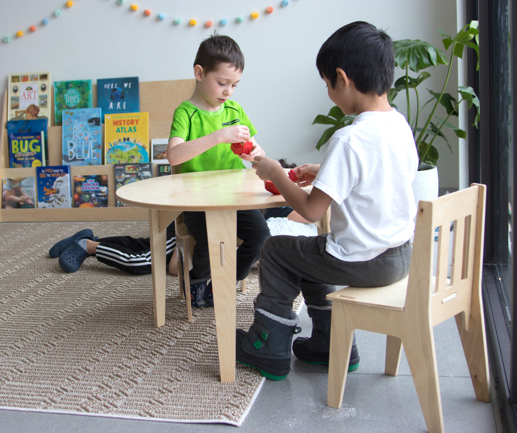 children sitting at a Montessori classroom  table and chairs