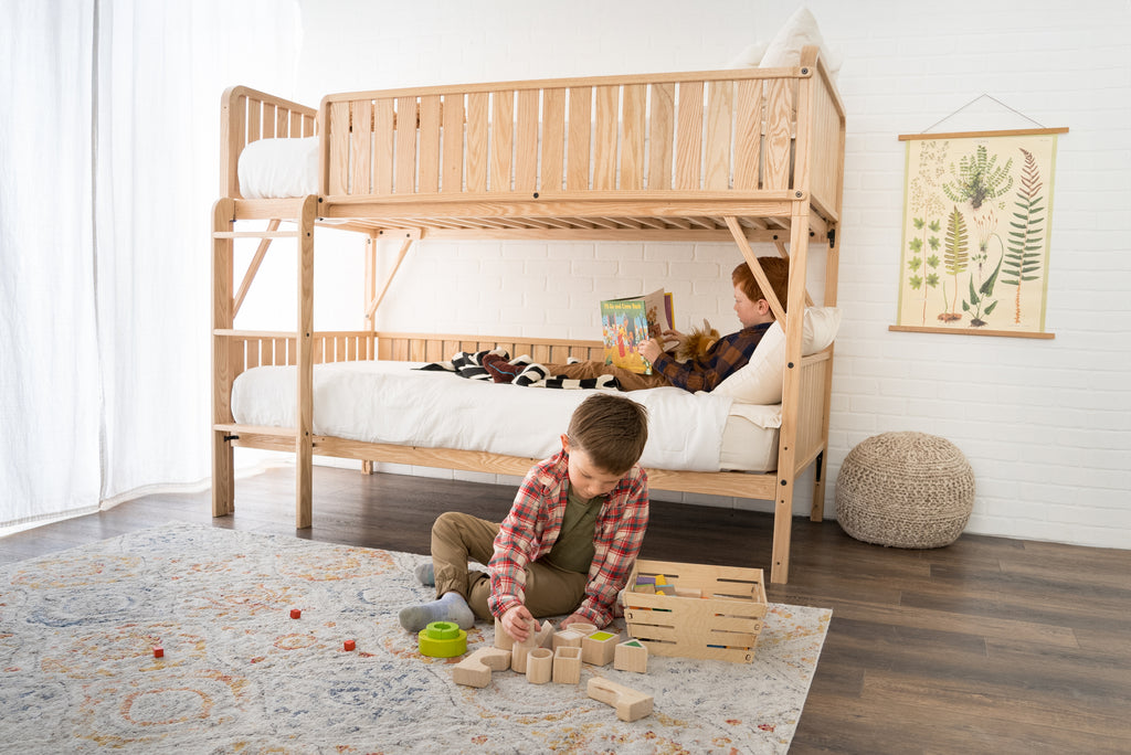 two boys in a bedroom with a bunk bed