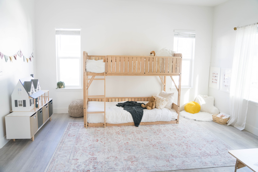 The 43" Sosta bunk bed for kids in a home space with a bench and dollhouse on top