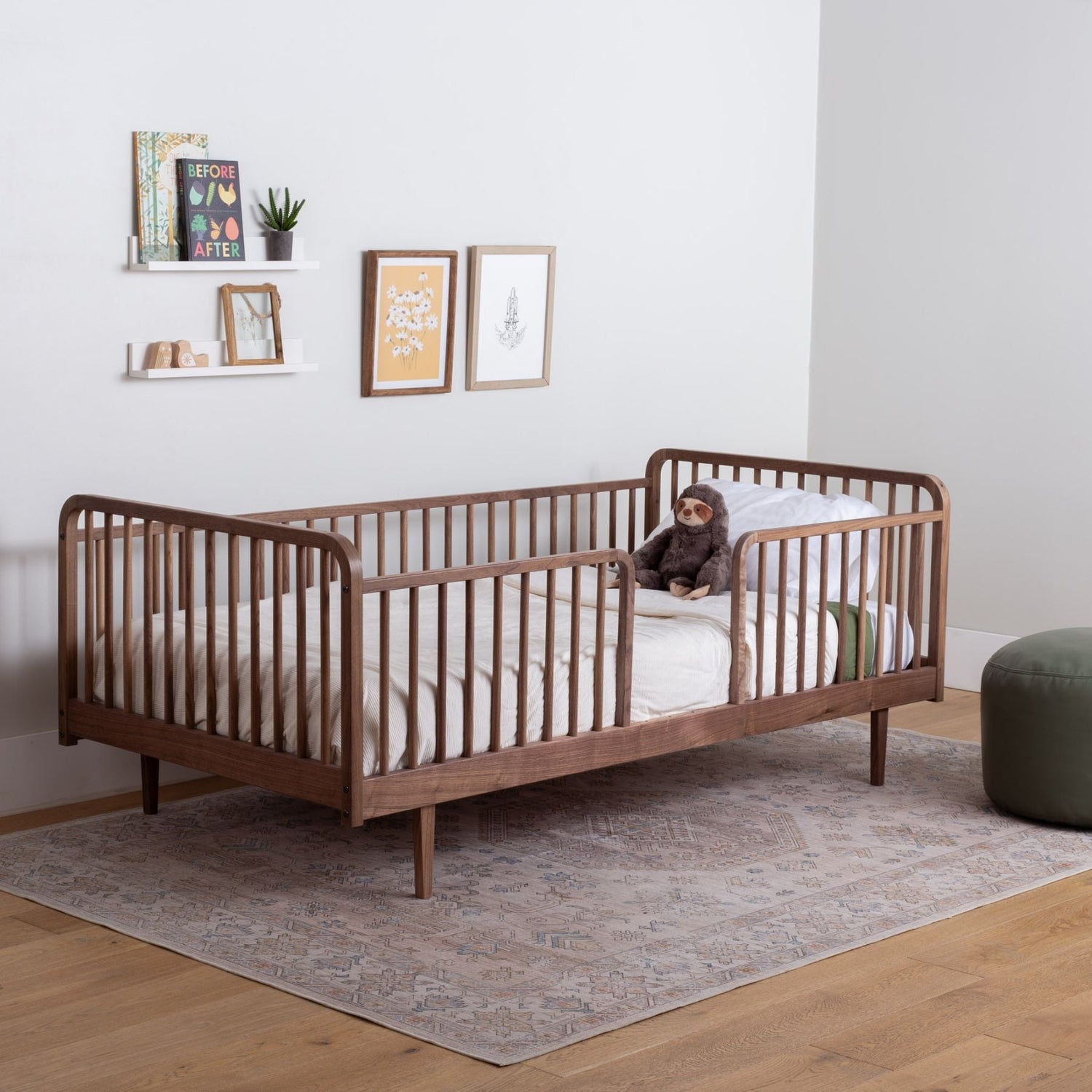 Raised Wooden Floor Bed with High Rails in a room with a rug and wall decorations.