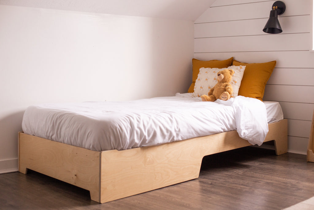 The twin size floor bed with one scoop side in the raised position