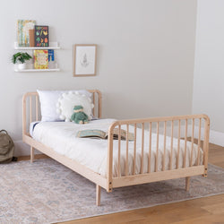 Wooden kids' bed with white bedding in a room setting