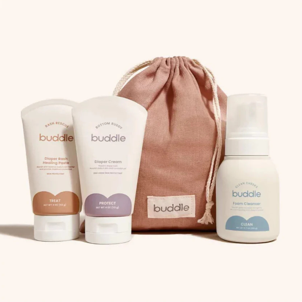 Buddle baby care products including creams and a bottle with a drawstring bag on a white background.