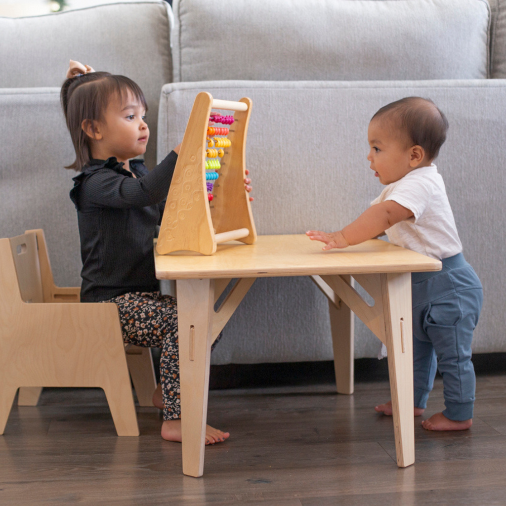 Siblings sharing a table and chair set