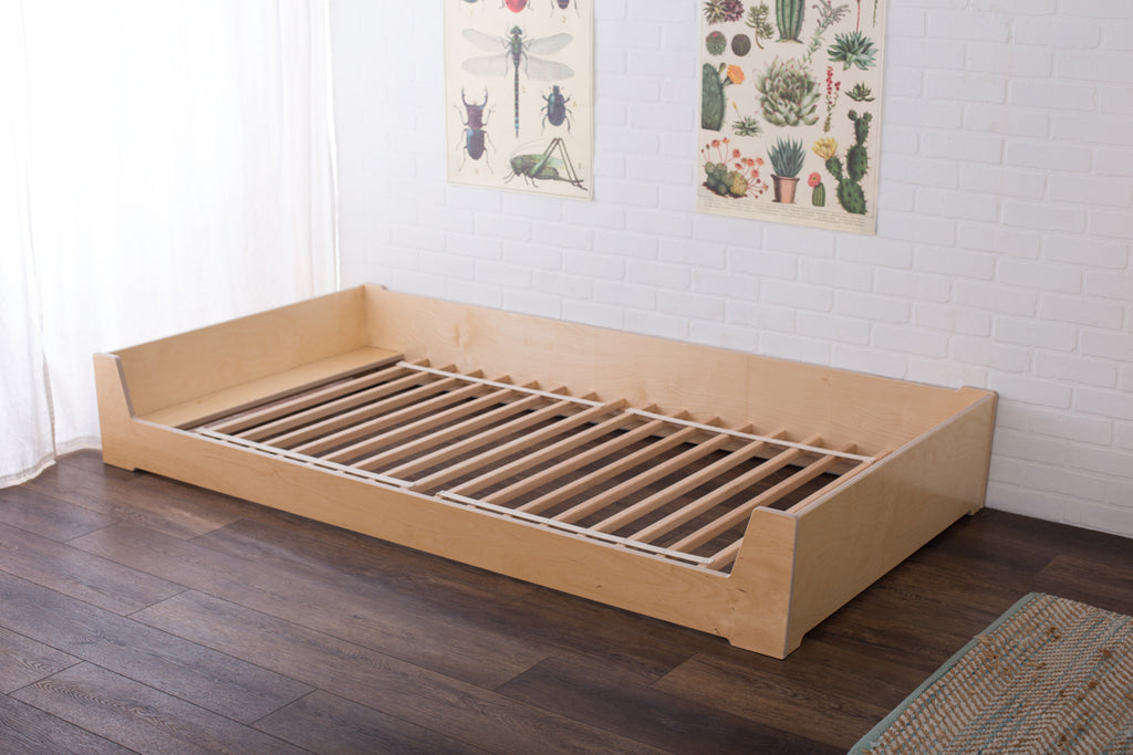 Birch floor bed without a mattress showing oak slats