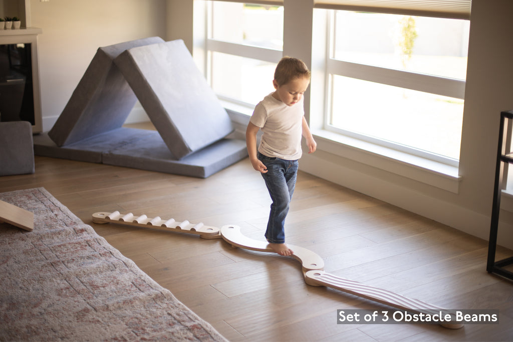 the 3 beam obstacle balance beam set with a child on it
