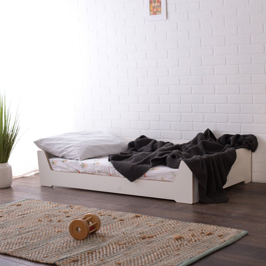 White Crib Floor Bed with Gray blanket 