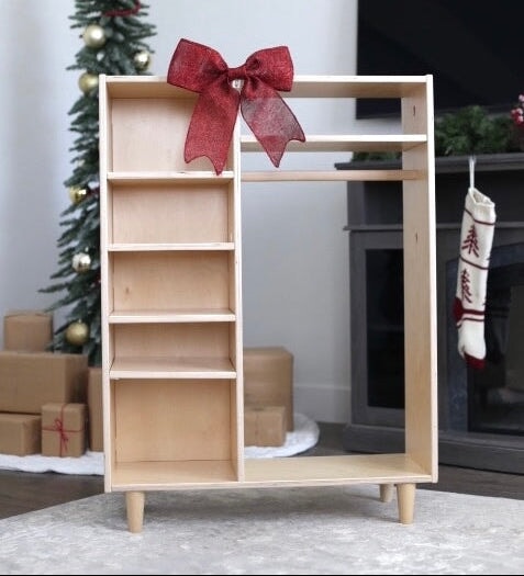 Wooden wardrobe with a red bow in a festive room with Christmas decorations.