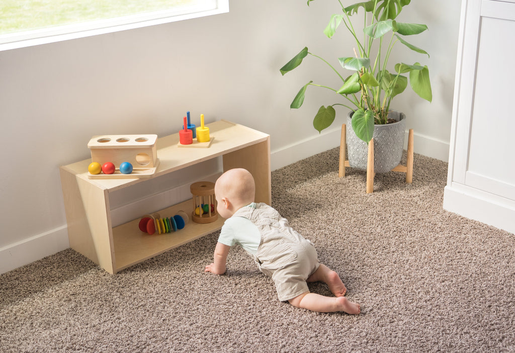 infant crawling towards toy shelf