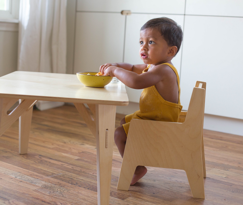 Young boy sitting on a child's table and chair set