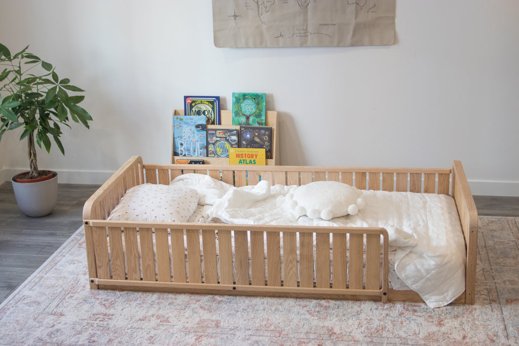 A toddler floor bed with two headboards, a full side rail, a 3/4 rail, and no legs