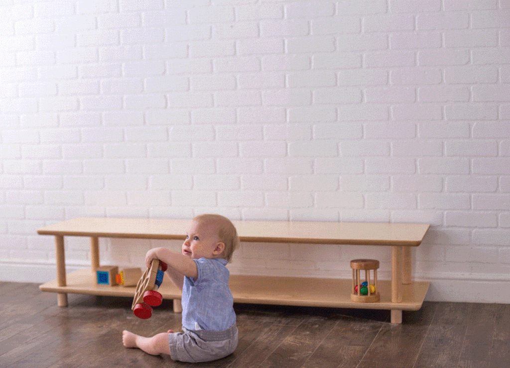 An animated GIF showing an infant, young toddler, and older child all in front of the Luce shelf as it grows behind them 