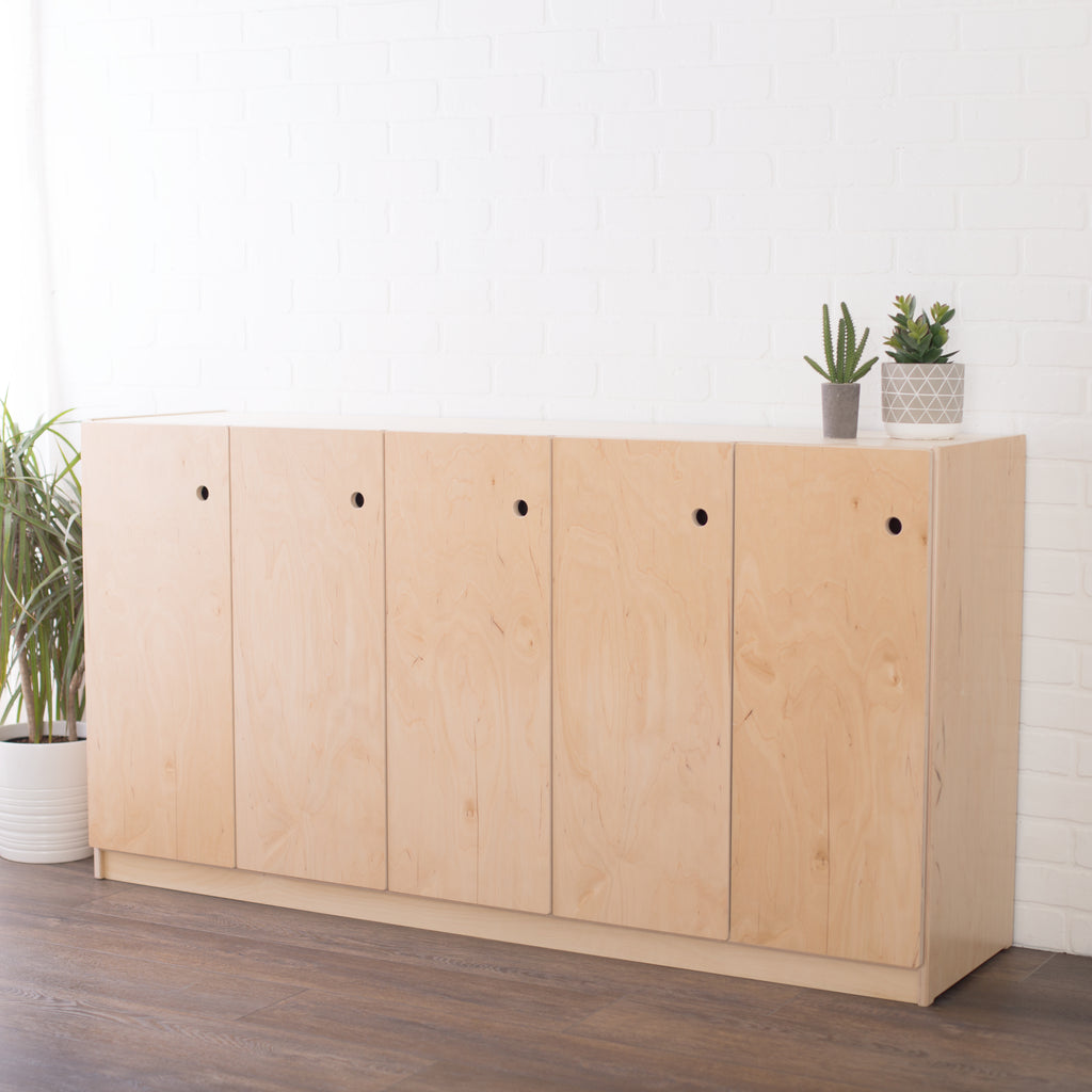 Wooden 1x5 locker storage with plants on top in a studio setting