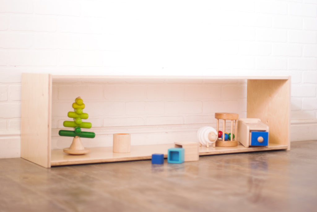 Front shot of a birch montessori low shelf with wooden toys